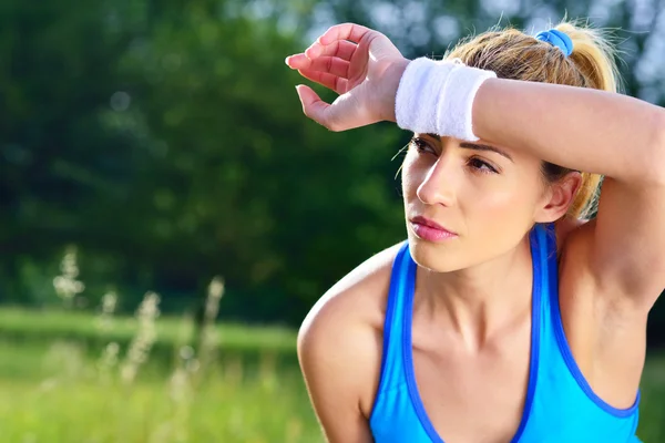 Junge Sportlerin ruht sich nach dem Laufen aus. — Stockfoto