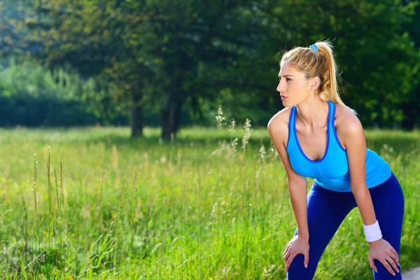 Junge Sportlerin ruht sich nach dem Laufen aus. — Stockfoto