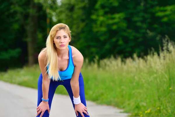 Young woman runner resting after workout session — Stock Photo, Image