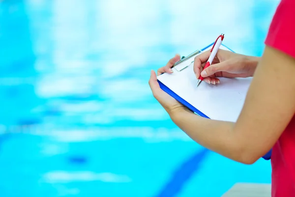 Pretty trainer writing in clipboard — Stock Photo, Image