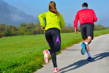 Genç çift parkta koşuyor.