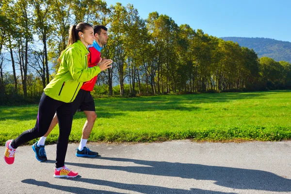 Young couple jogging in park — Stock Photo, Image