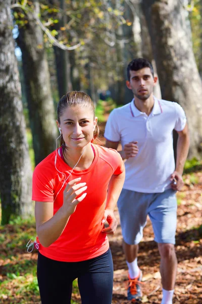 Pareja joven corriendo en el parque — Foto de Stock