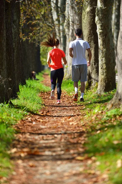 Jong koppel joggen in park — Stockfoto