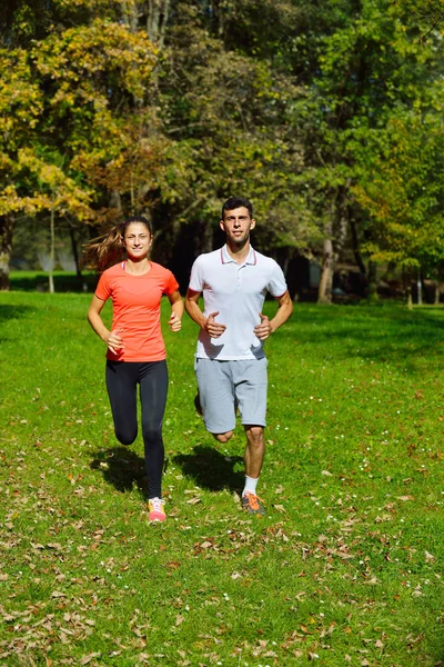 Jong koppel joggen in park — Stockfoto