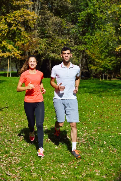 Pareja joven corriendo en el parque — Foto de Stock