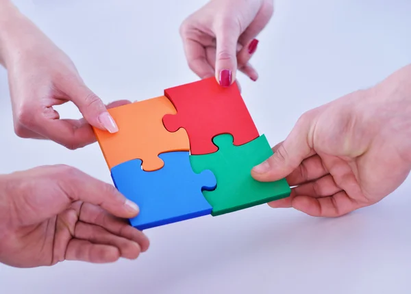 Business people assembling jigsaw — Stock Photo, Image