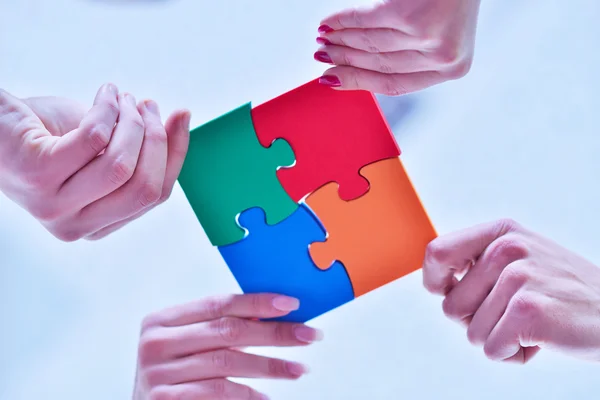 Business people assembling jigsaw — Stock Photo, Image