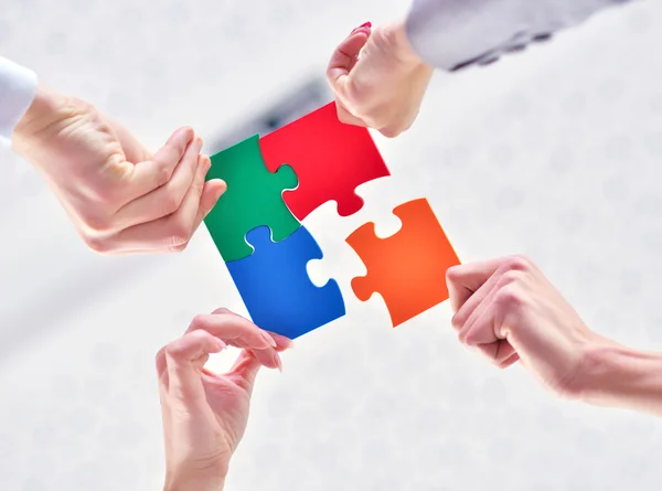 Business people assembling jigsaw — Stock Photo, Image