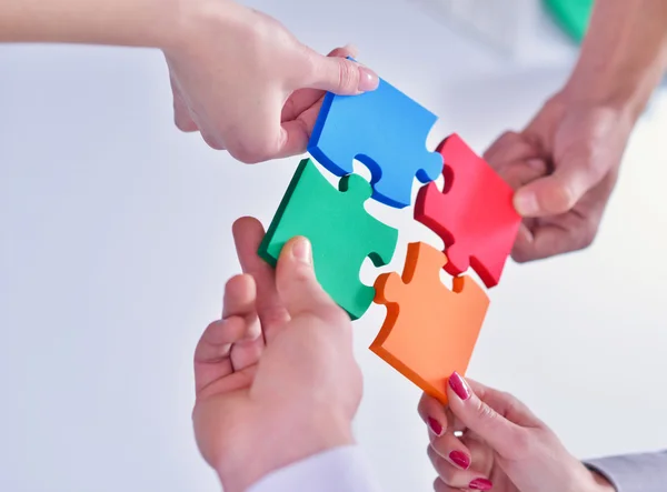 Business people assembling jigsaw — Stock Photo, Image