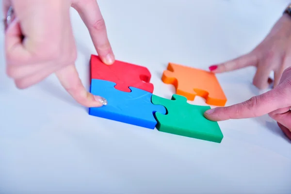 Business people assembling jigsaw — Stock Photo, Image