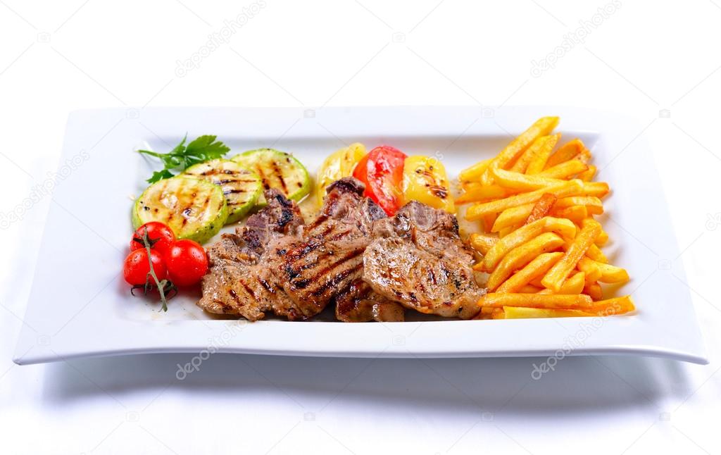Tasty grilled chicken with french fries and vegetables
