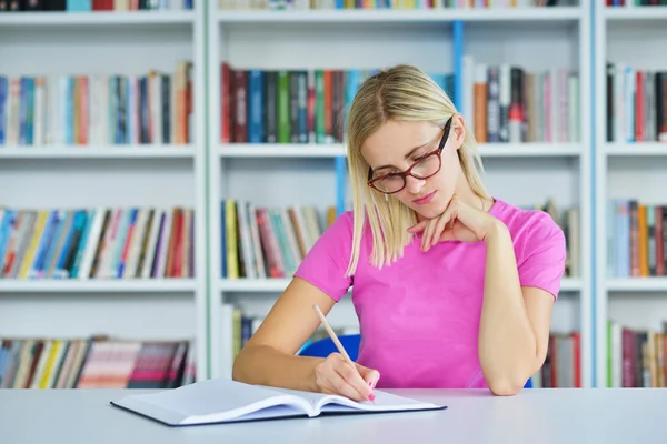 Mujer estudiando en la biblioteca — Foto de Stock