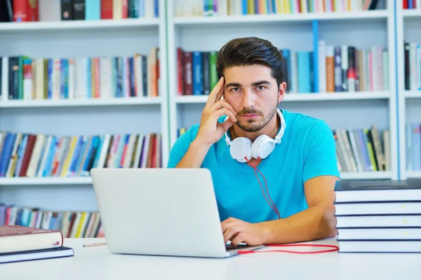 Manlig student arbetar i ett bibliotek — Stockfoto