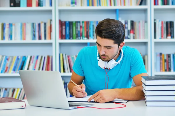 Étudiant masculin travaillant dans une bibliothèque — Photo