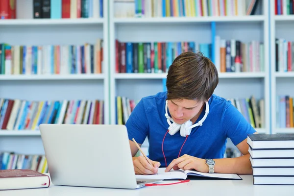 Male student working in a library — Stock Photo, Image