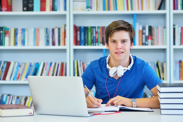 Manlig student arbetar i ett bibliotek — Stockfoto