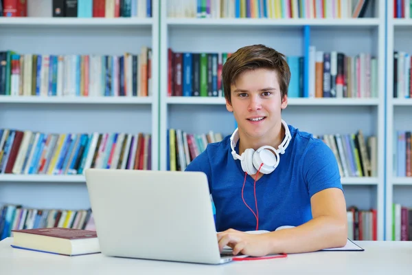 Mannelijke student werkt in een bibliotheek — Stockfoto