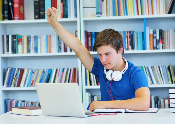 Manlig student arbetar i ett bibliotek — Stockfoto