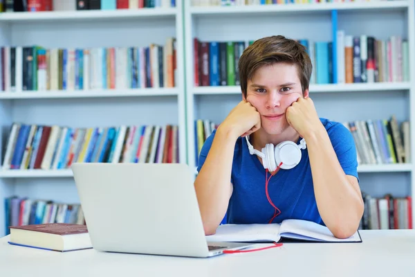 Manlig student arbetar i ett bibliotek — Stockfoto