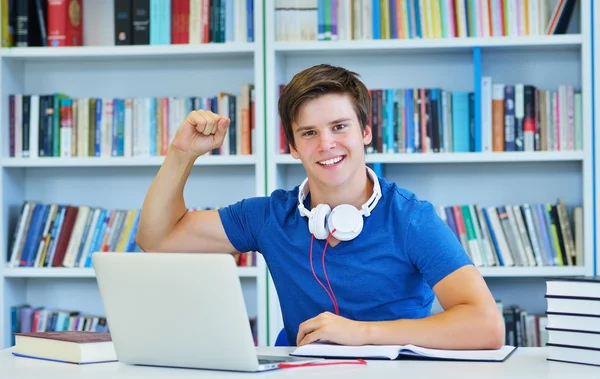 Mannelijke student werkt in een bibliotheek — Stockfoto