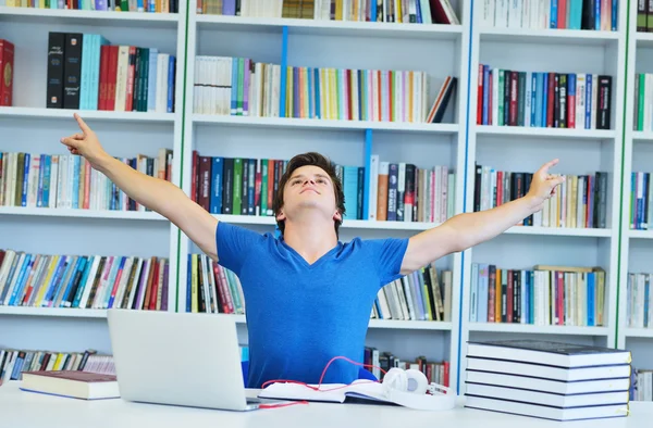 Mannelijke student werkt in een bibliotheek — Stockfoto