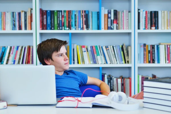Manlig student arbetar i ett bibliotek — Stockfoto