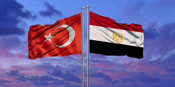 Turkey and Egypt flag waving in the wind against white cloudy blue sky together. Diplomacy concept, international relations.