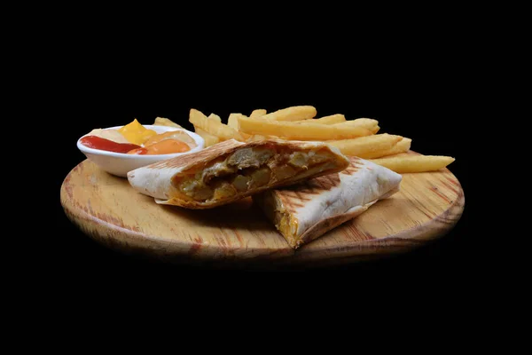 French tacos with chicken. Served with french fries, mayonnaise, ketchup and mustard on a black background