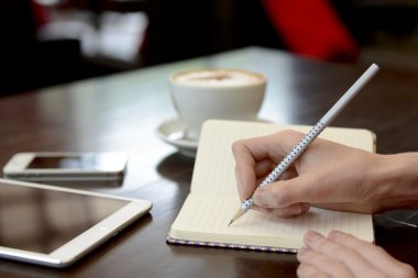 Bir kafede bir tablet ve bir fincan kahve ile çalışma