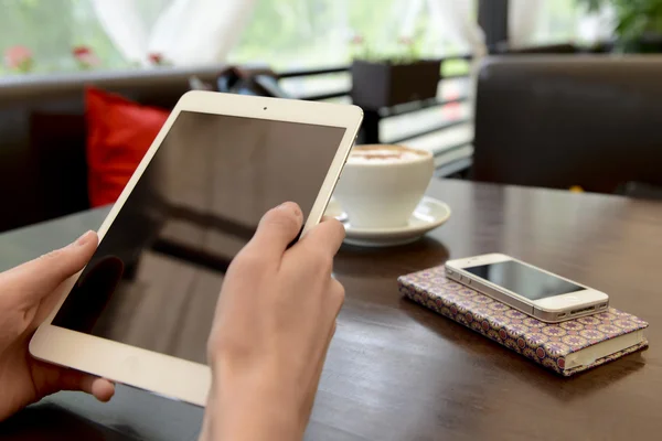 Működő-ban egy kávézó, egy tablet és egy csésze kávé — Stock Fotó