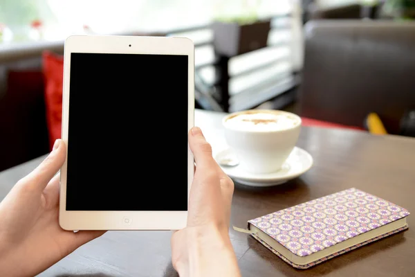 Working in a cafe with a tablet and a cup of coffee — Stock Photo, Image