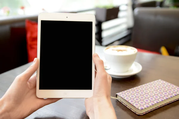 Trabajando en un café con una tableta y una taza de café — Foto de Stock