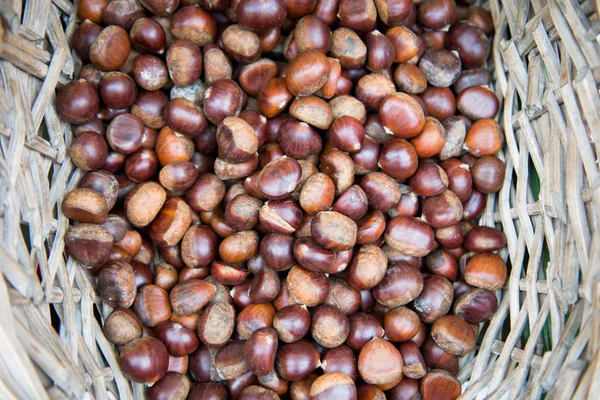 Fresh chestnuts in a basket on the market — Stock Photo, Image