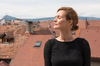 Kiremitli çatıları arka plan üzerinde çekici bir kadın.