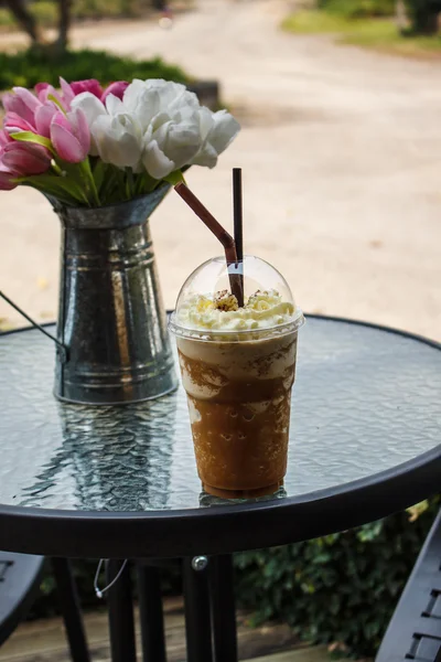 Iced coffee smoothie on table  and flower vase