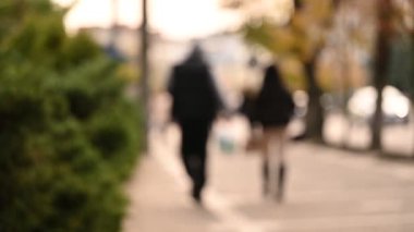 Şehir parkında yürüyen insanların bulanık görüntüsü