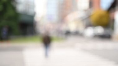 Arka planda insanların olduğu şehir caddesinin bulanık görüntüsü