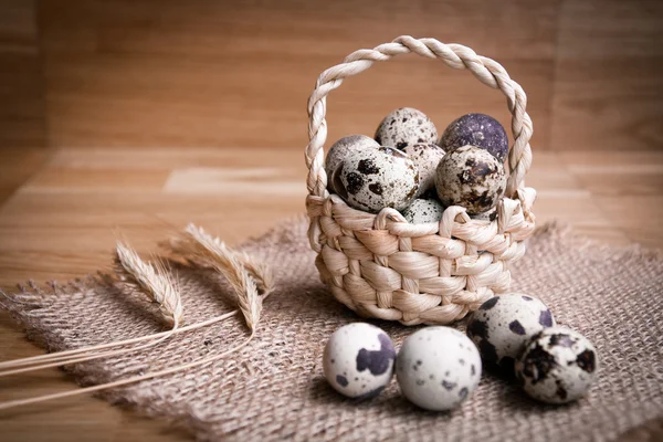 Bird eggs in wicker basket on wooden background — Stock Photo, Image