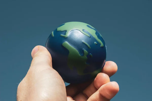 Earth Day. Male hand holding earth in his hands. Human saving planet earth. There is no planet b concept. Earth day concept. Protecting the world is in our hands