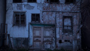 Ağaçları ve kırık camları olan terk edilmiş eski bir ev. Parçalanan bir bina. Güvenli olmayan yerler. Korku evi konsepti. Cadılar Bayramı konsepti.