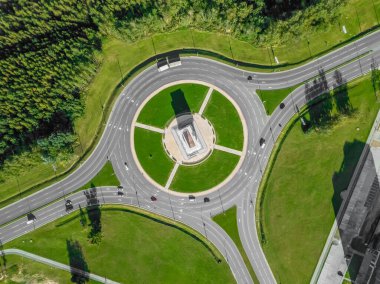 Güneşli bir yaz gününde üç yönlü çatalla çevre yolunun havadan görünüşü. Şehir altyapısı. Çevre yolunun güzel üst manzarası. Farklı yol yönü