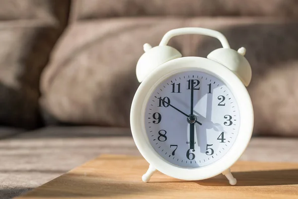 Reloj Despertador Blanco Sobre Una Mesa Madera Sobre Fondo Sofá —  Fotos de Stock