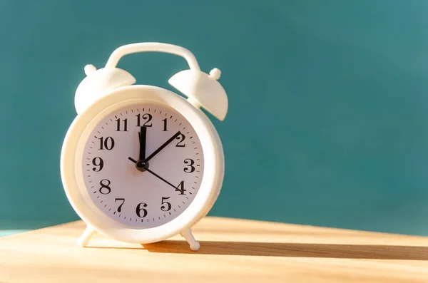 Relógio Alarme Branco Fica Uma Mesa Madeira Fundo Azul Luz — Fotografia de Stock