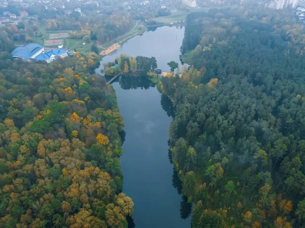 view from the bird\'s eye view of the beautiful river and colorful autumn forest on a cloudy day, the photo with the drone.