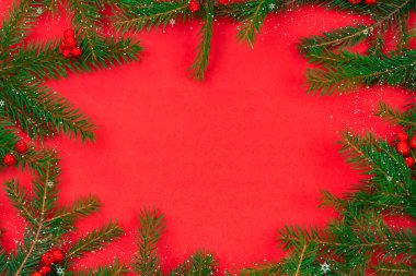 Kırmızı Rowan böğürtlenli Noel ağacı dalları, Baka, kırmızı arka planda fotokopi alanı olan kar, üst manzara. Noel ve yeni yıl için tebrik kartı. Güzel Noel arkaplanı.