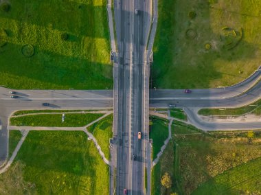 Yoldaki İHA 'nın üst görüntüsü, güneşli bir günde şehirde arabalarla köprü. Şehirdeki yollar ve köprüler
