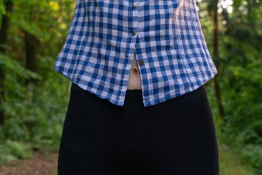 Spor yaptıktan sonra genç ve narin bir kadının göbeği tişörtten görülebiliyor.