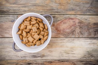 Tahta zemin üzerinde çikolata olan mısır gevreği kasesi, fotokopi alanı, üst görünüm