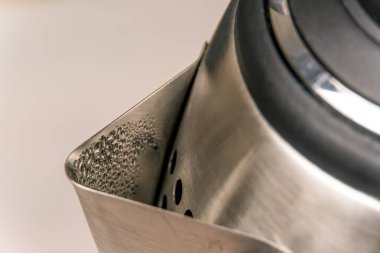 Su damlaları, arka plan, kopyalama alanı olan gri bir elektrikli su ısıtıcısının makrofotoğrafçılığı. seçici odak